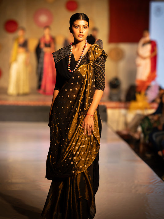 Model wearing a traditional saree with a black blouse on a runway. Bani Thani Jaitoon Saree by Soulweaves