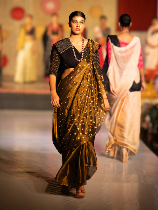 Model wearing a traditional saree with a black blouse on a runway. Bani Thani Jaitoon Saree by Soulweaves