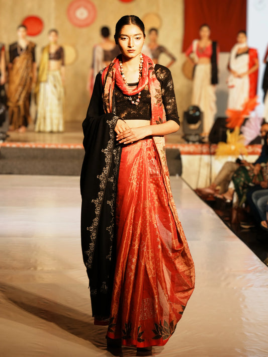 Model wearing a traditional outfit with a red and black saree on a fashion show runway. Bani Thani Padmapriya Saree by Soulweaves