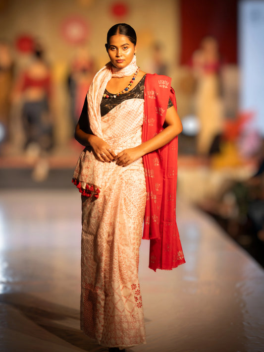 Model wearing a white saree with red border on a fashion show stage. Bani Thani Rudraja Saree by Soulweaves